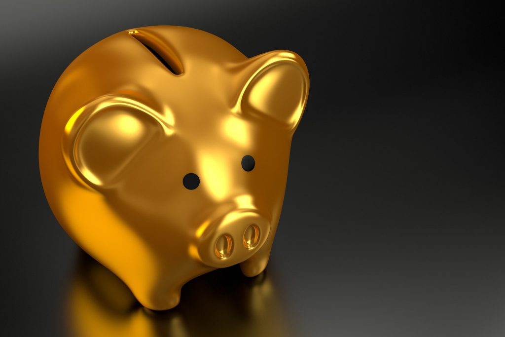 Tirelire dorée en forme de cochon sur fond noir